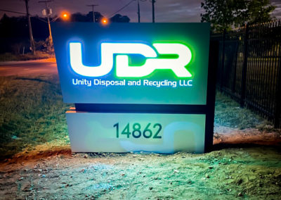 Night view. Illuminated Monument sign that reads UDR Unity Disposal and Recycling LLC