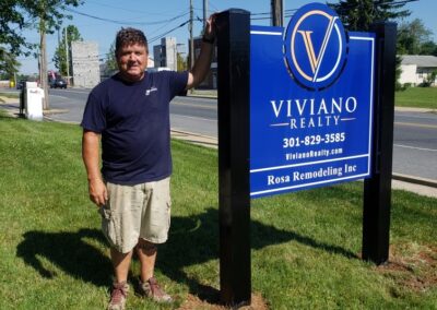 DMS Sign Connection, Inc. installer Dean stands next to Viviano Realty Post and Panel Sign